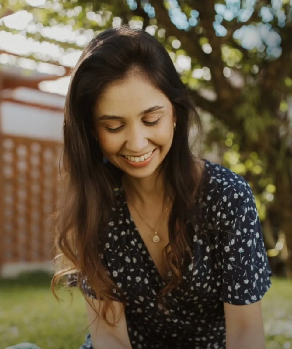 Monique Paula, nutricionista infantil, sorrindo no jardim